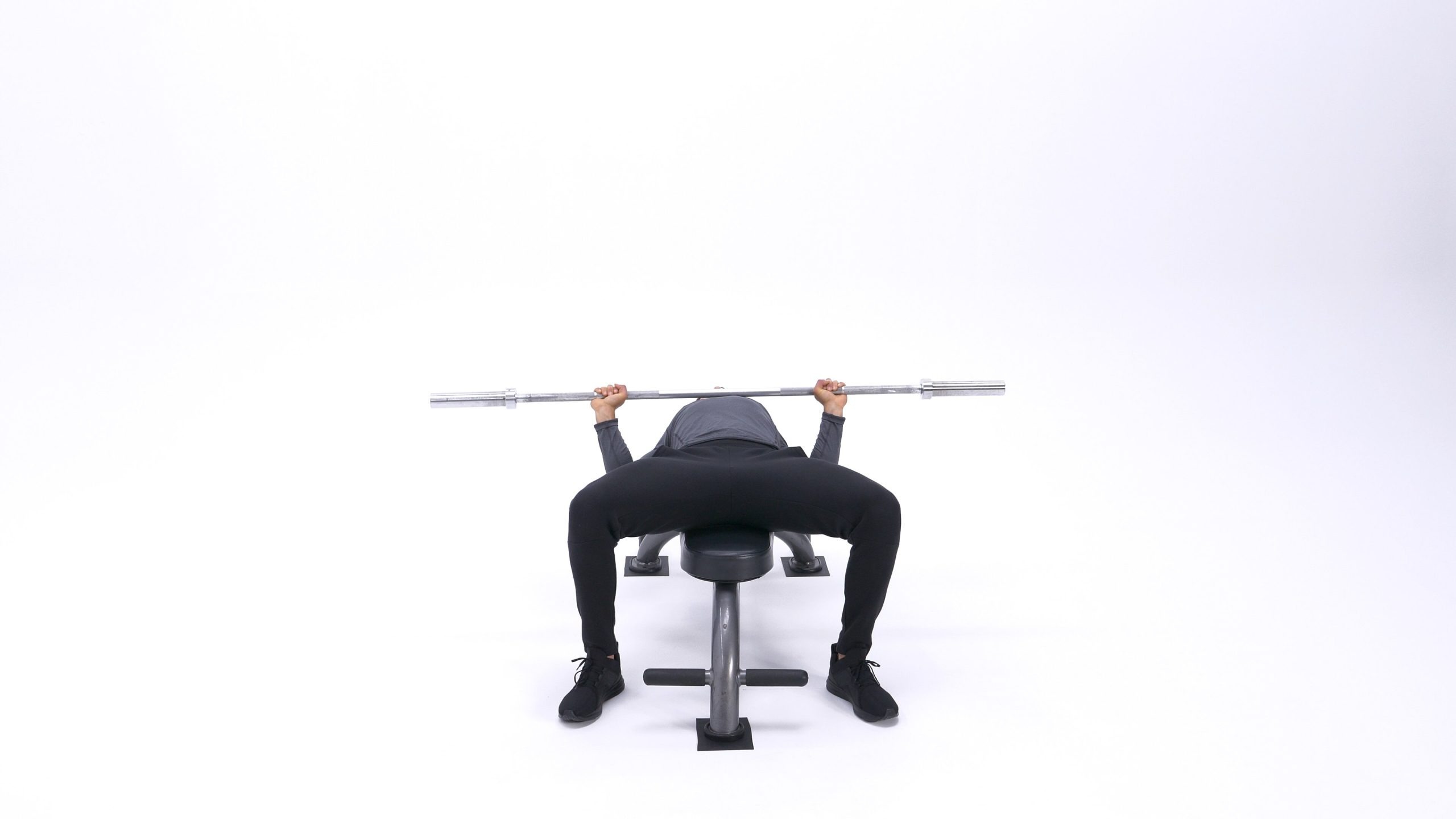 تصویر ابتدای حرکت پرس سینه با هالتر، نشان‌دهنده‌ی وضعیت شروع و کشش عضلات سینه.