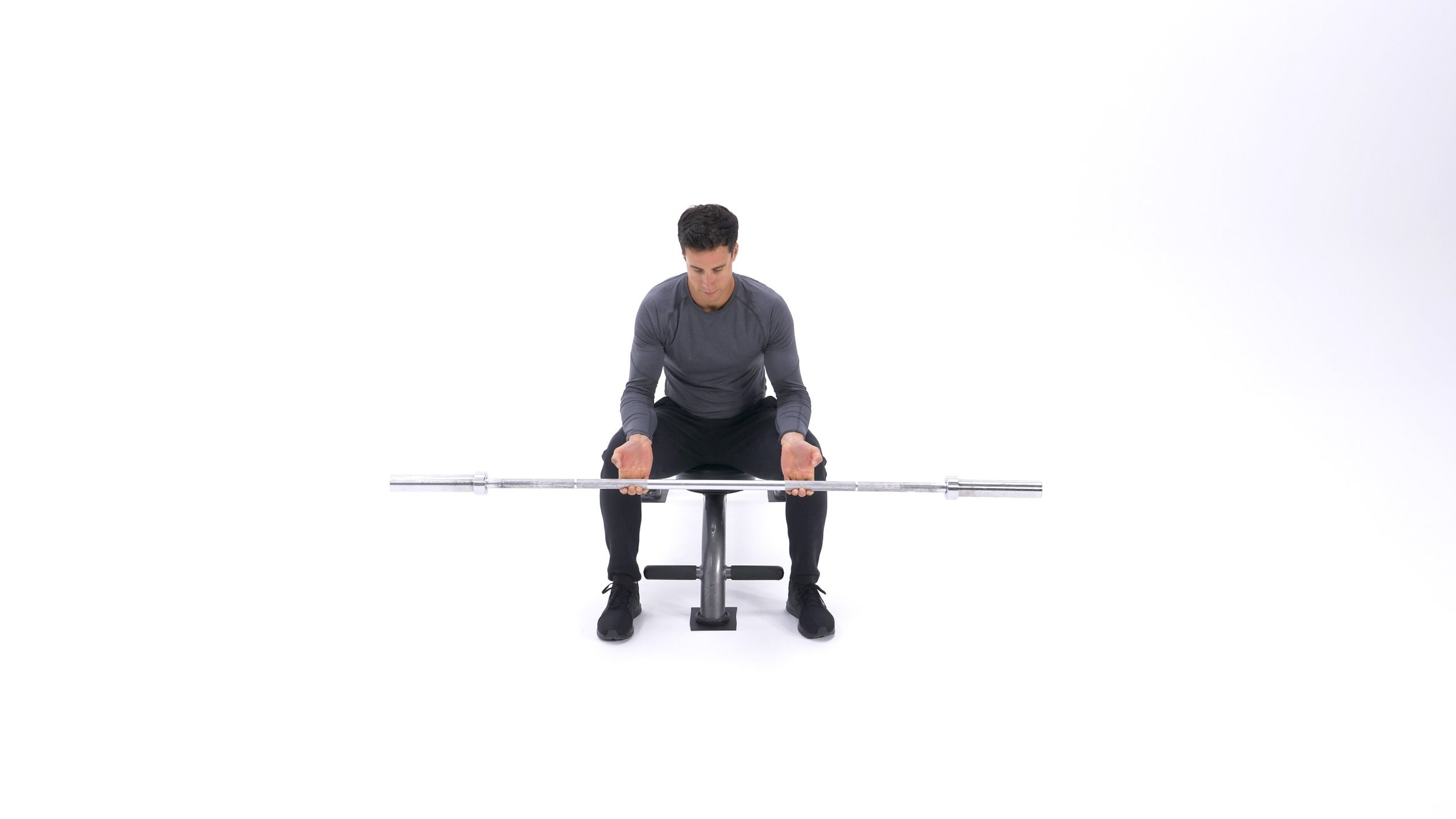 تصویر ابتدای حرکت چرخش انگشتان دست ایستاده، زمانی که فرد نشسته و با انگشتان کشیده خود هالتر را گرفته است.