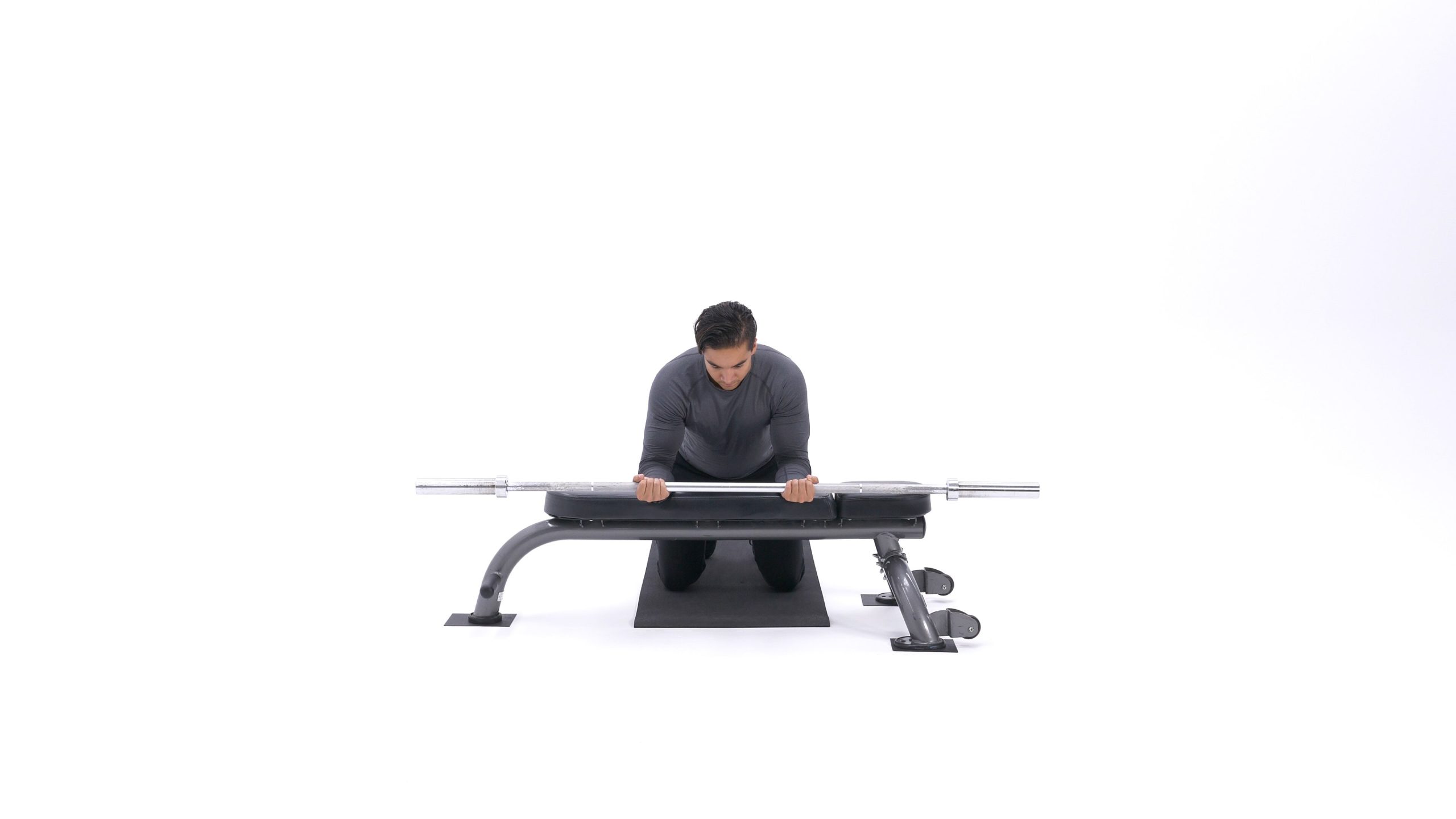 تصویر انتهای حرکت چرخش مچ با هالتر روی میز، زمانی که عضلات ساعد به انقباض کامل رسیده‌اند و هالتر بالا آورده شده است.