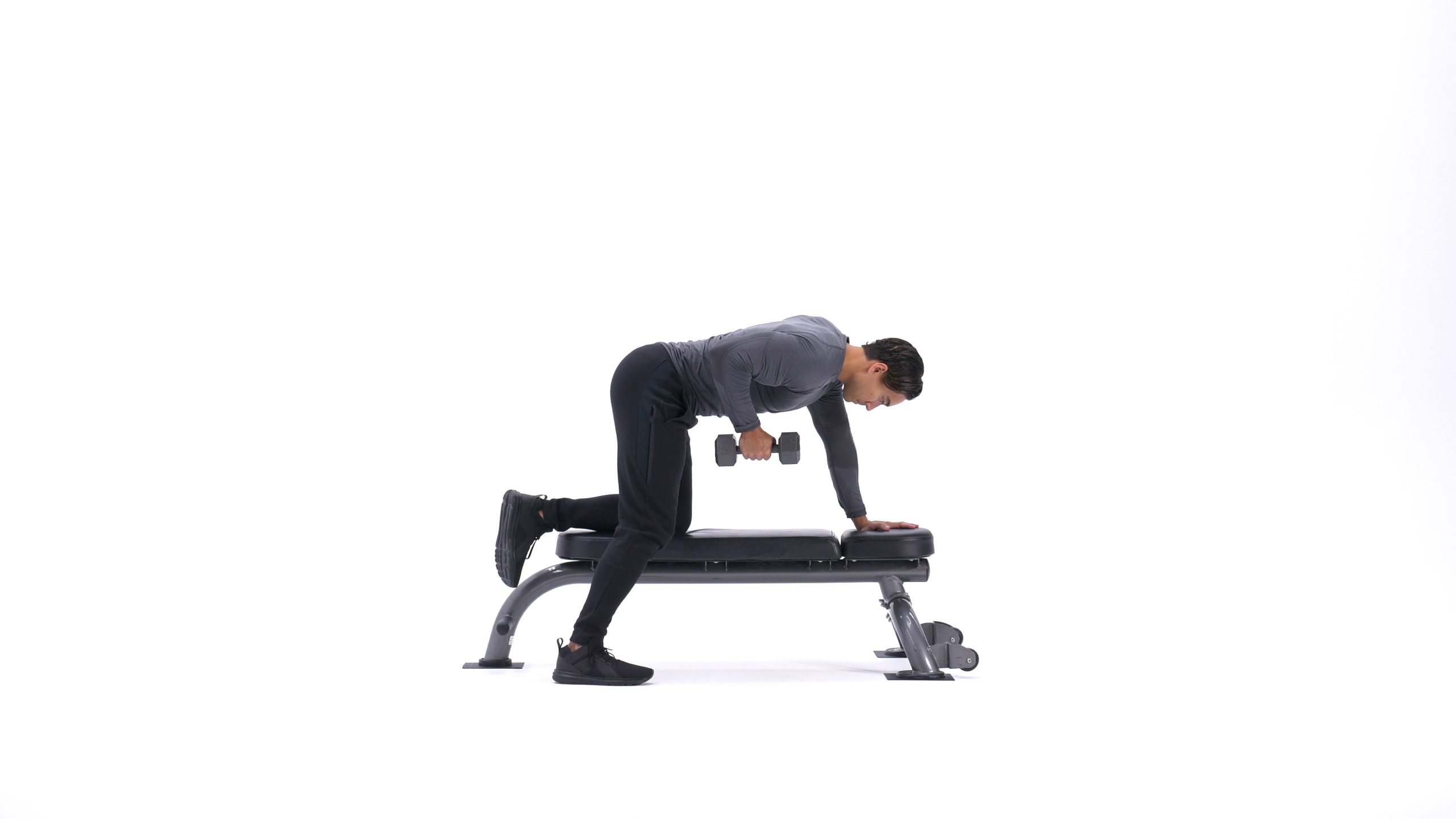 پایان حرکت زیربغل دمبل تک خم، فرد دمبل را تا نزدیکی پهلو بالا آورده و عضلات زیربغل را در انقباض کامل نگه داشته است.